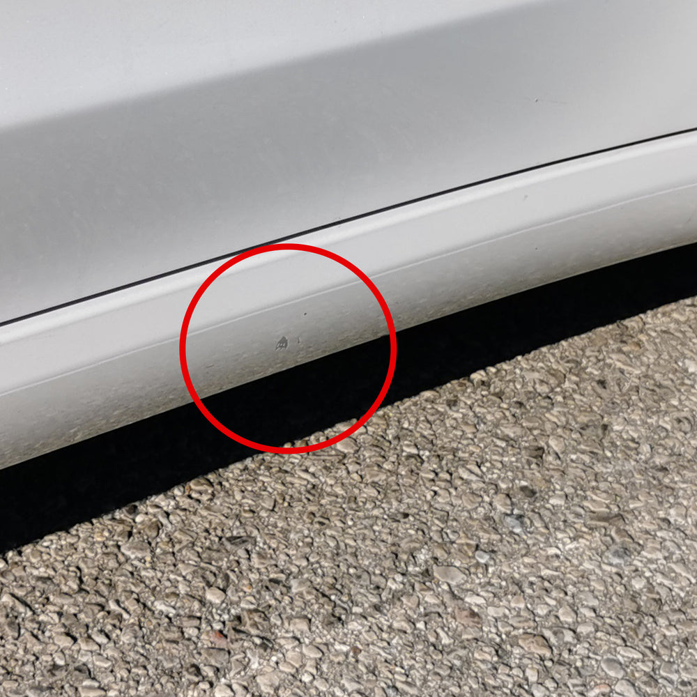 Rot markierter Lackschaden am Seitenschweller eines weißen Tesla Model 3