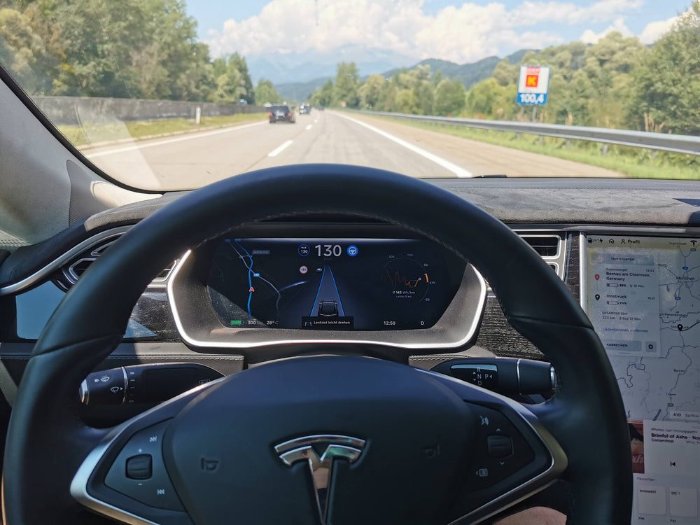 Blick über das Lenkrad eines Tesla Model X auf die Autobahn