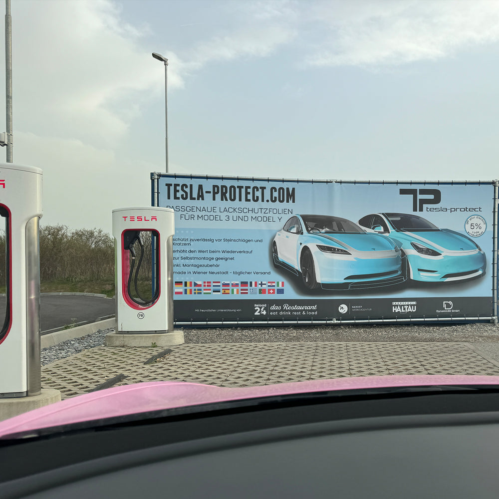 Tesla-Protect Werbebanner neben Tesla-Superchargern